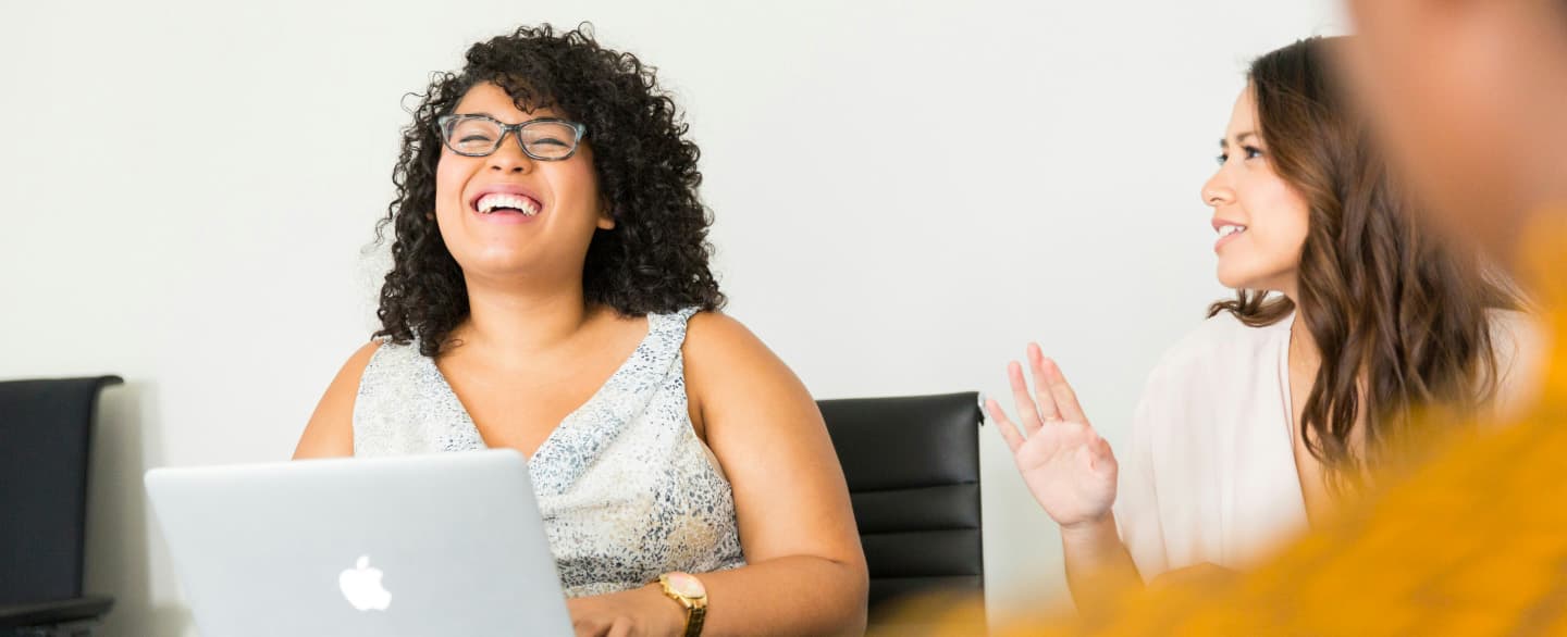 Person laughing while working on a laptop