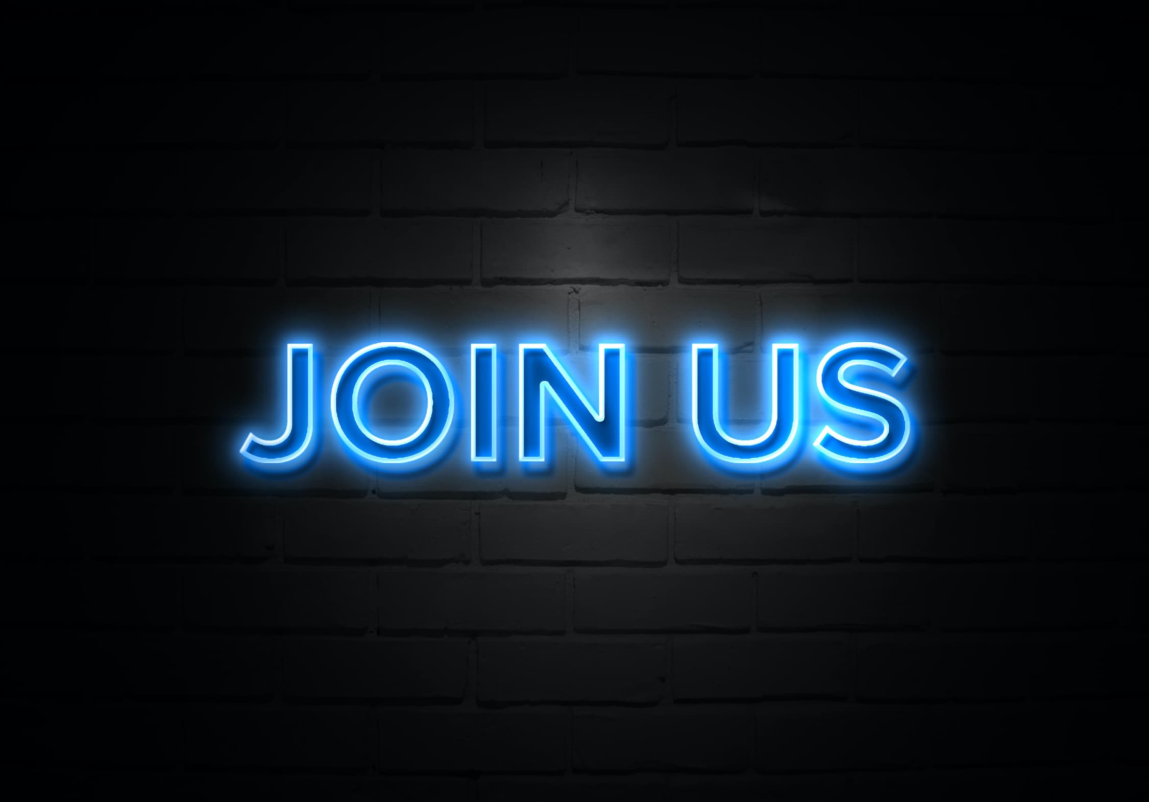 Join Us neon Sign on brickwall